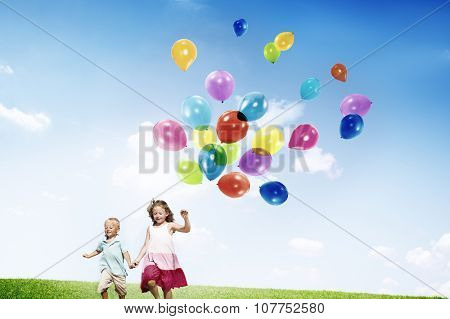 Little Girl and Boy Outdoors Holding Balloons Concept