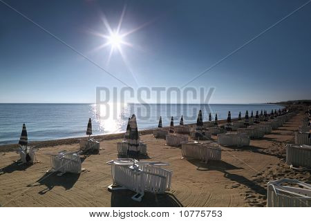 Sonnenliege mit Sonnenschirmen sind morgen am Strand erbaute