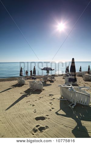 Paar steht in der Nähe von Wasser, morgens am Strand die Liegestühle leer basieren auf