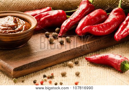Red Sauce, Spices And Pepper On A Kitchen Board