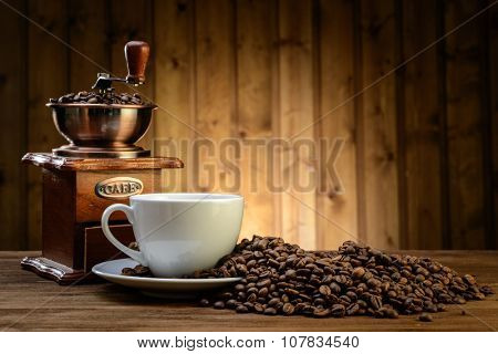 still life with coffee beans and old coffee mill on the wooden background  