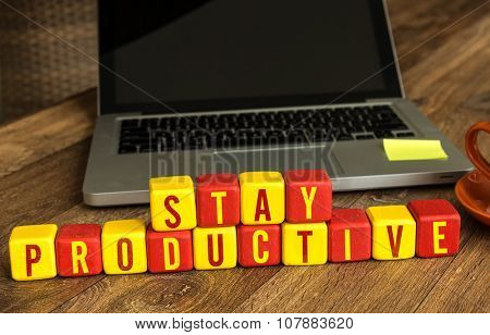 Stay Productive written on a wooden cube in office desk