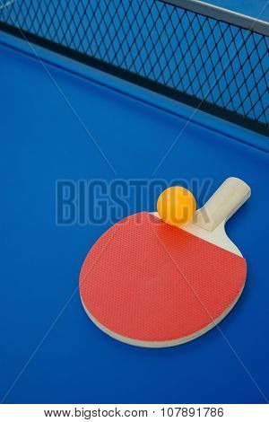 Pingpong Racket And Ball And Net On A Blue Pingpong Table Vertical
