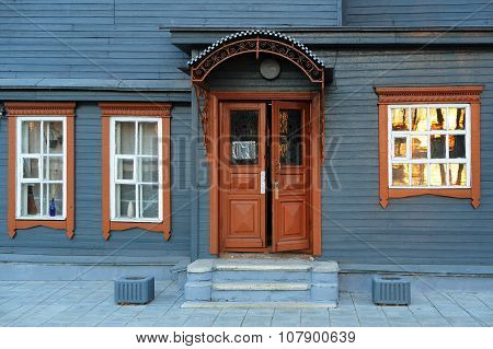 Blue Grey Wooden House Facade With Brown Open Door