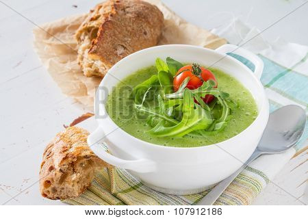 Arugula and tomatoes puree soup in white bowl