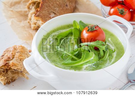 Arugula and tomatoes puree soup in white bowl