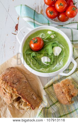 Arugula and tomatoes puree soup in white bowl