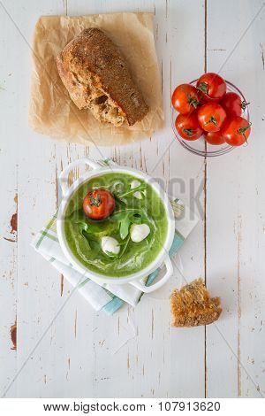 Arugula and tomatoes puree soup in white bowl