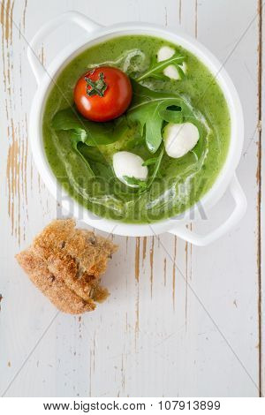 Arugula and tomatoes puree soup in white bowl