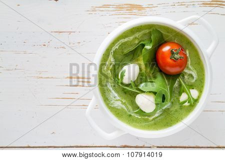 Arugula and tomatoes puree soup in white bowl