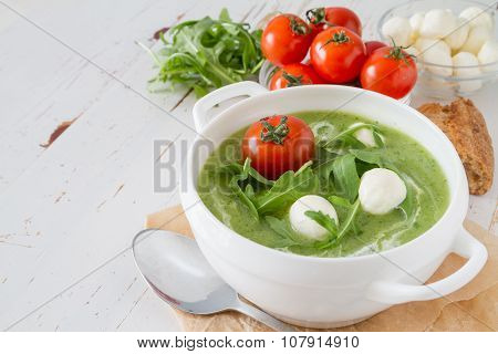 Arugula and tomatoes puree soup in white bowl
