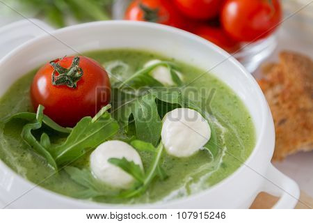 Arugula and tomatoes puree soup in white bowl