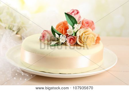 Cake with sugar paste flowers, on light background