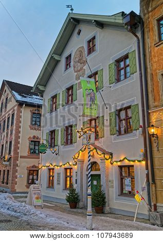 GARMISCH-PARTENKIRCHEN GERMANY - JANUARY 06 2015: Exterior of the enchanting Bavarian-styled house in Garmisch-Partenkirchen with green shutters beautiful facade painting and Christmas decoration