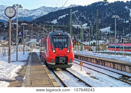 Garmisch-Partenkirchen, Germany - January 7, 2015: Train arriving at Garmisch-Partenkirchen railway station on a sunny winter day. Garmisch-Partenkirchen is a mountain resort town in Bavaria southern Germany in the heart of the Alps.