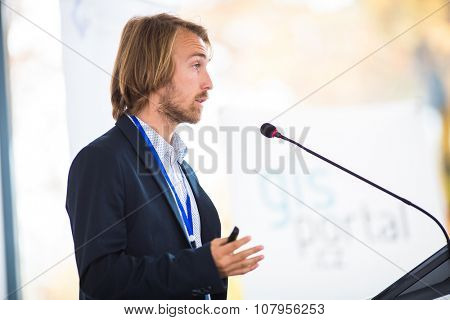 Handsome young man giving a speech at a conference