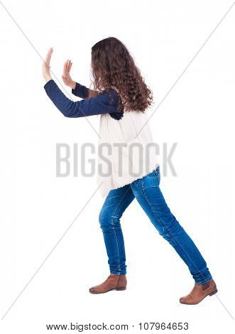 back view of woman pushes wall. Isolated over white background. Rear view people collection. backside view of person. curly girl put her hands on the obstacle.