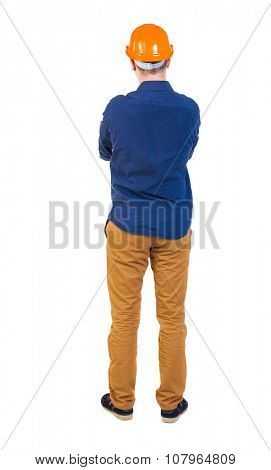 Backview of an engineer in construction helmet stands. Standing young guy. Rear view people collection.  backside view of person.  Isolated over white background. 
