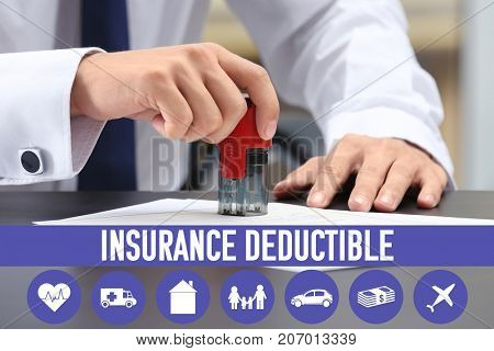 Notary public stamping document at table in office. Concept of insurance deductible