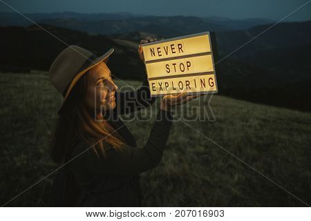 Cozy Portrait Of  Woman In Hat  With Box With Text Never Stop Exploring  Against The Background Of T