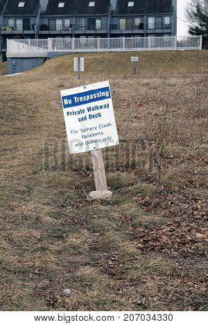 BAY VIEW, MICHIGAN / UNITED STATES - MARCH 30, 2017: A sign, posted beside the Little Traverse Wheelway, indicates that the walkway and deck are private, and for Tannery Creek residents and guests only.