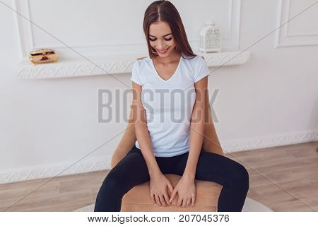 Woman with a big breast in a white T-shirt is sitting in a chair. Mock-up.