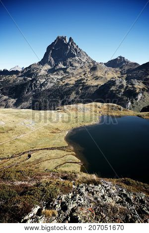 Midi Dossau Peak reflected and Gentau lake. Ossau Valley, Pyrenees National Park, Pyrenees, France.