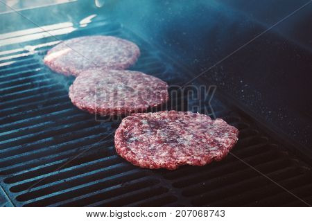 Hamburgers On Grill With Flames Cooked To Perfection