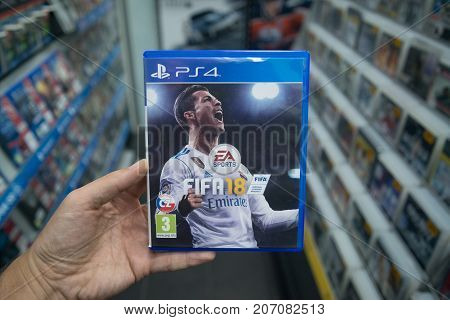 Bratislava, Slovakia, october 2 2017: Man holding Fifa 18 videogame on Sony Playstation 4 console in store