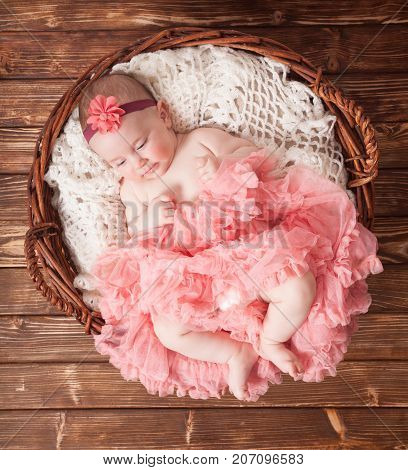 Adorable baby girl in pink tutu lying in the basket. Newborn photography