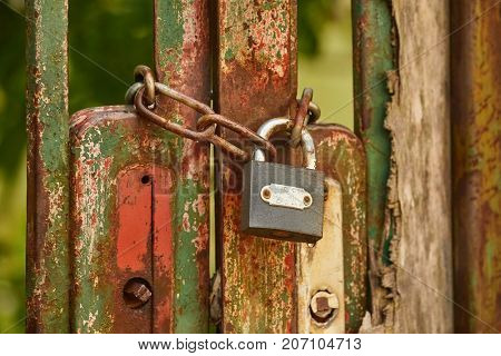 Metal gate locked by a padlock and chain