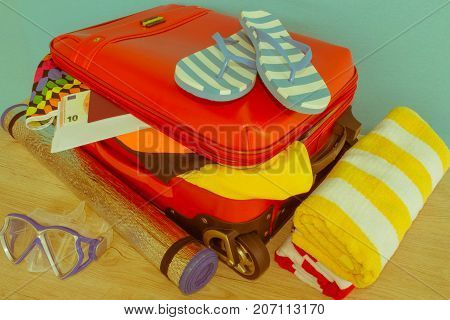 Suitcase with things for spending summer vacation. Anticipation of voyage. Women's clothes and accessories in red suitcase - Retro color