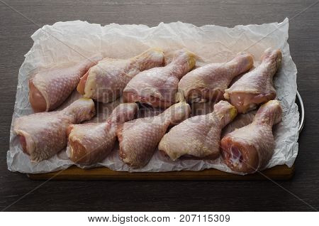 Fresh raw chicken legs arrangement on a kitchen cutting board