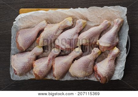 Fresh raw chicken legs arrangement on a kitchen cutting board