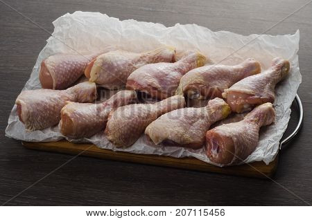 Fresh raw chicken legs arrangement on a kitchen cutting board
