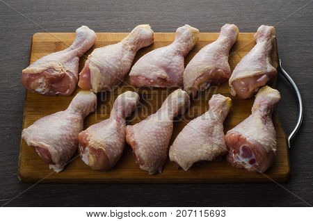 Fresh raw chicken legs arrangement on a kitchen cutting board