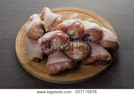 Fresh raw chicken legs arrangement on a kitchen cutting board