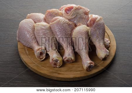 Fresh raw chicken legs arrangement on a kitchen cutting board