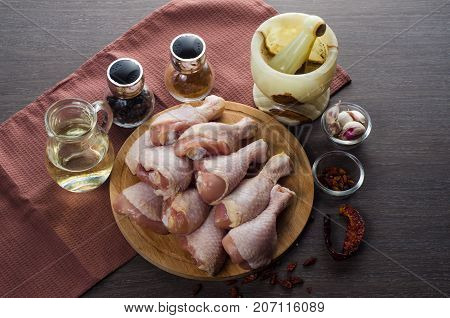 Fresh raw chicken legs arrangement on a kitchen cutting board