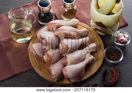 Fresh raw chicken legs arrangement on a kitchen cutting board