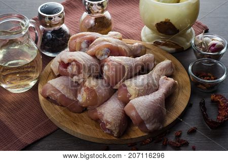 Fresh raw chicken legs arrangement on a kitchen cutting board