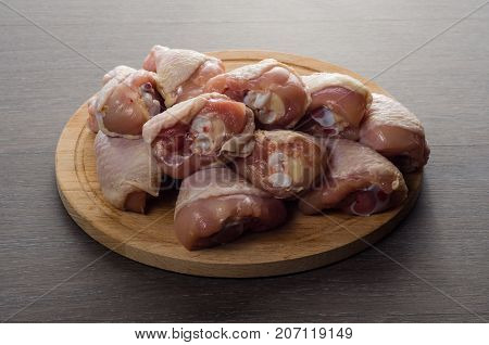 Fresh raw chicken legs arrangement on a kitchen cutting board