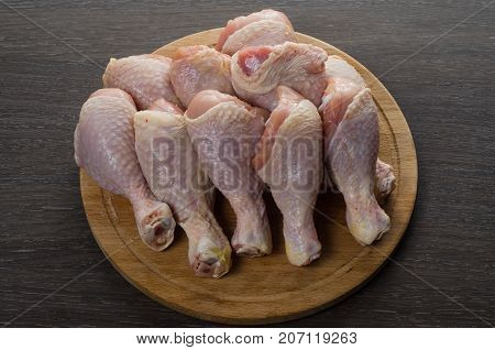 Fresh raw chicken legs arrangement on a kitchen cutting board