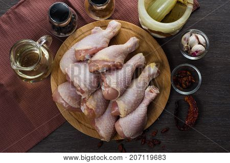 Fresh raw chicken legs arrangement on a kitchen cutting board