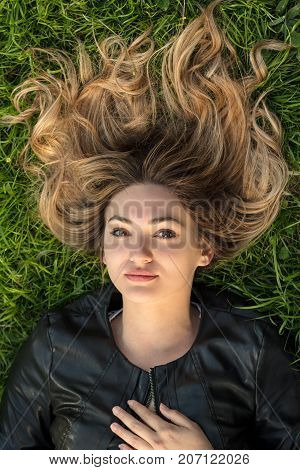 Teenage girl laying in grass at the park