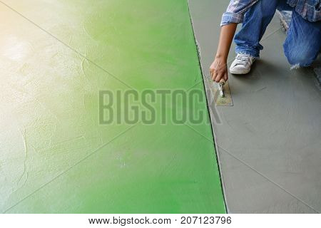 Plasterer plastering walkway with sand cement plaster