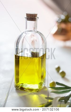 Olive oil and vegetables on the white wooden background