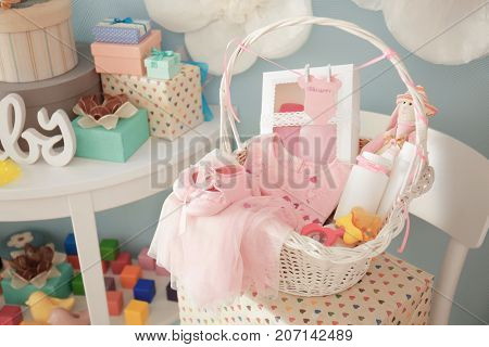 Wicker basket with gifts for baby shower indoors