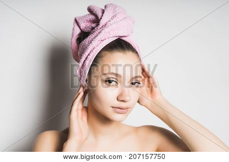 young girl with a towel on her head straightens her hair