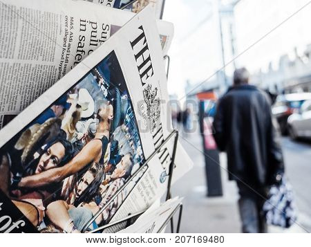 PARIS FRANCE - OCT 3 2017: Pedestrians near the Times newspaper with socking title and photo at press kiosk about the 2017 Las Vegas Strip shooting in United States with about 60 fatalities and 527 injuries